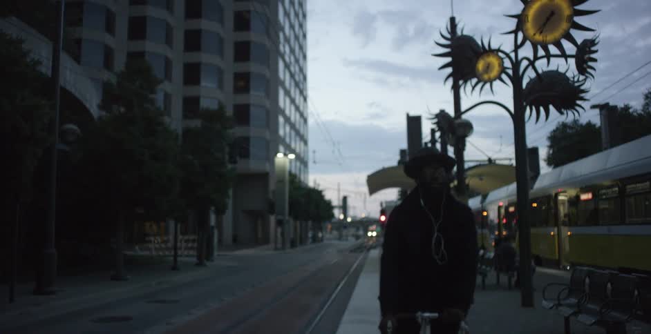 Black man cycles at the train station