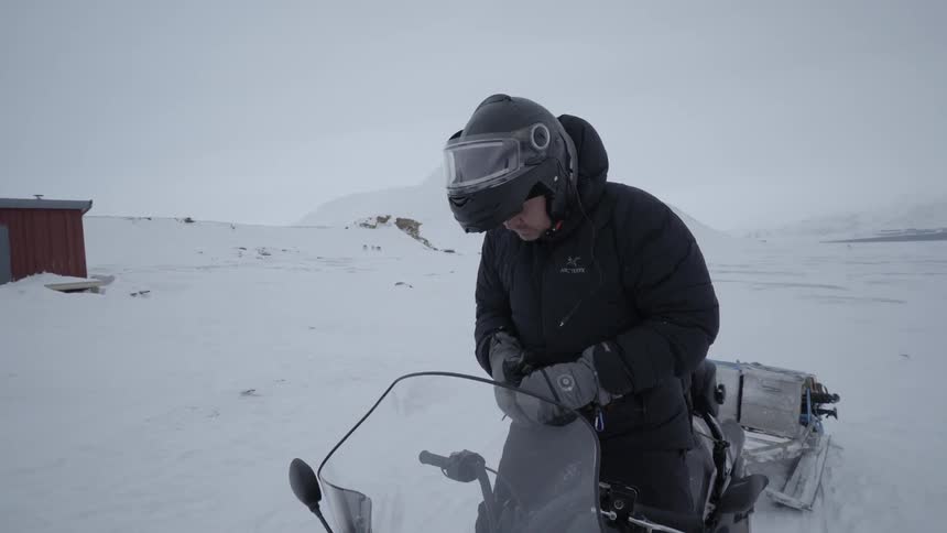A man starts up a snowmobile