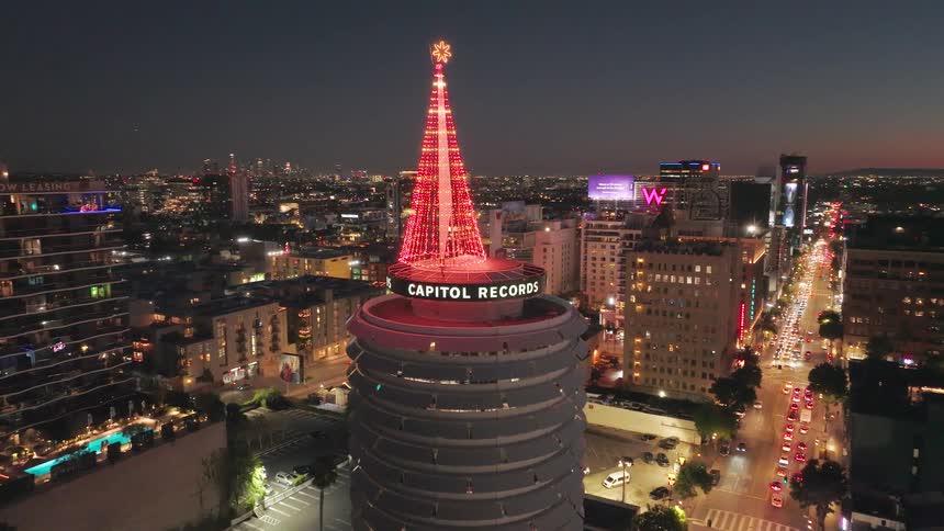 Aerial shot of a christmas tower on a building in a metropolis at night