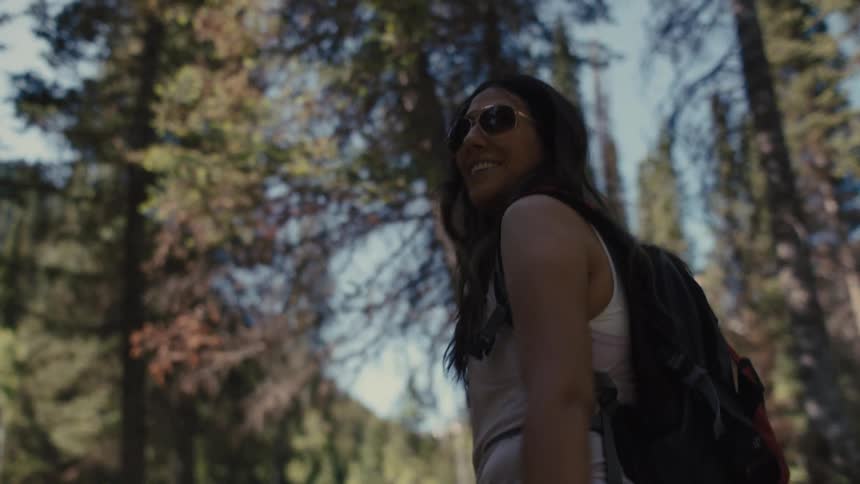 The hiker looks back and smiles while walking