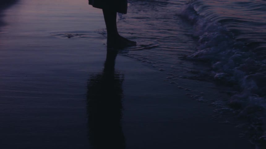 Sea water from a beach touching a persons bare feet