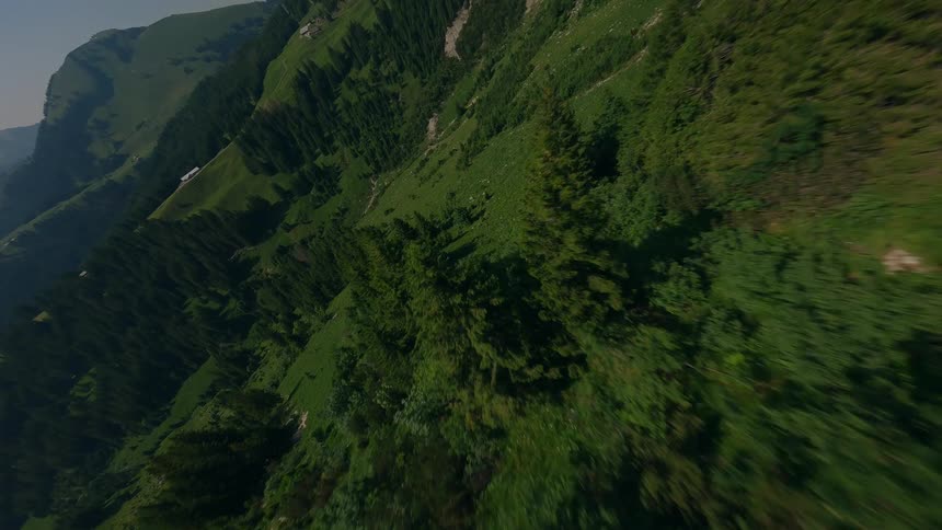 Drone Shot of a mountain range surrounded by forest around midday