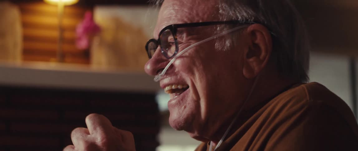 Elderly man happily vibrating and placing his hand on his forehead