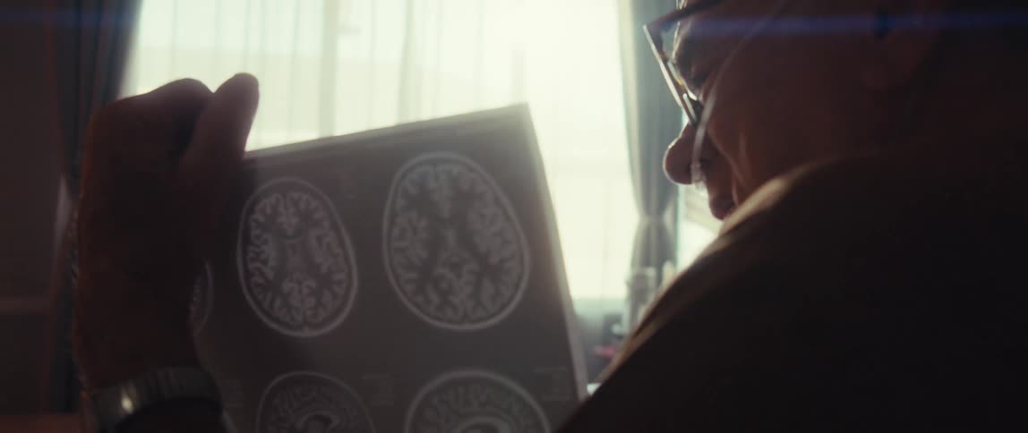 A man shows his doctor on the laptop his ct scan