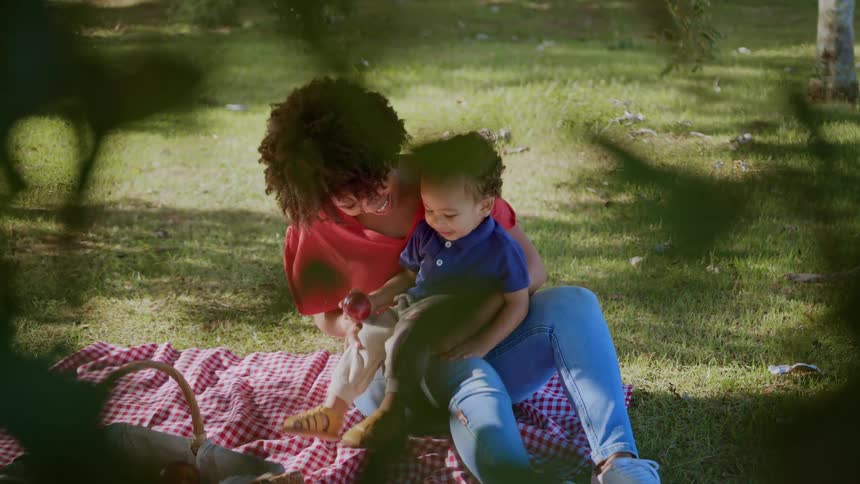 A mother rocks her son on her lap