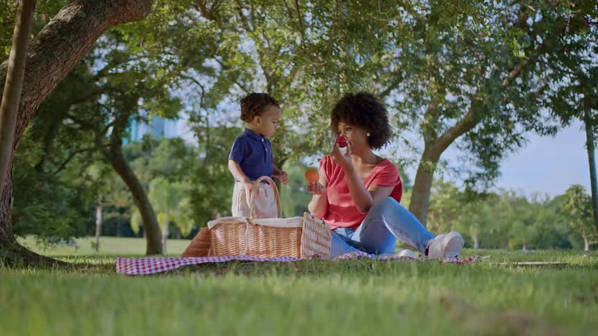 A mother offers her son an apple or orange and the boy picks the apple