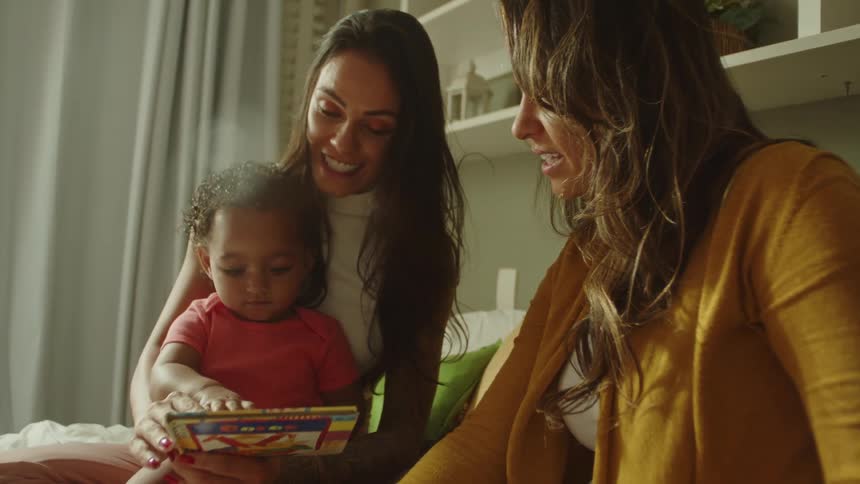 A mother is showing a book to her baby
