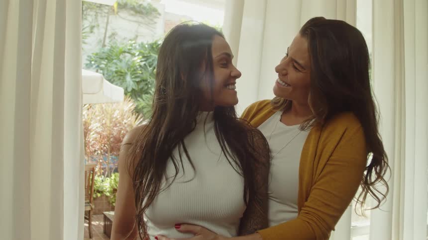 Two women are hugging and smiling