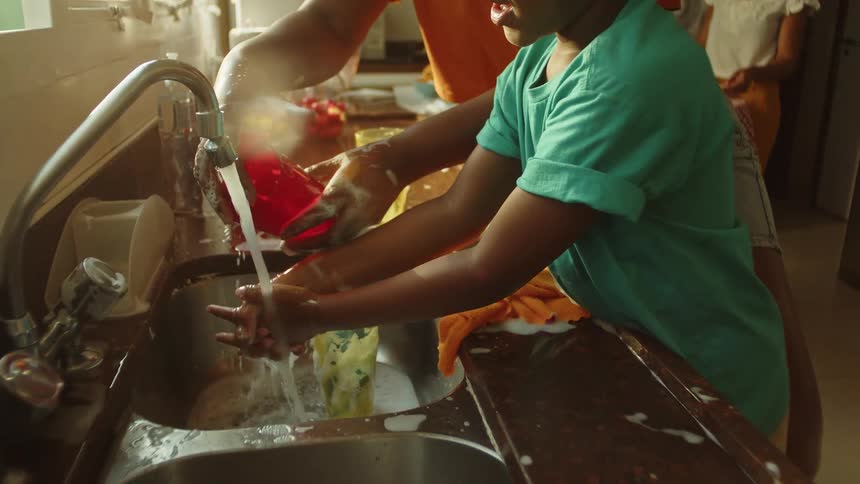 A man and boy are washing dishes together