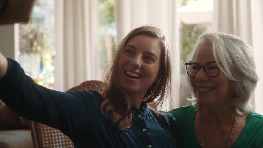 A mother and daughter take a selfie together