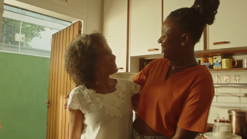 A mother and daughter hug while one laughs
