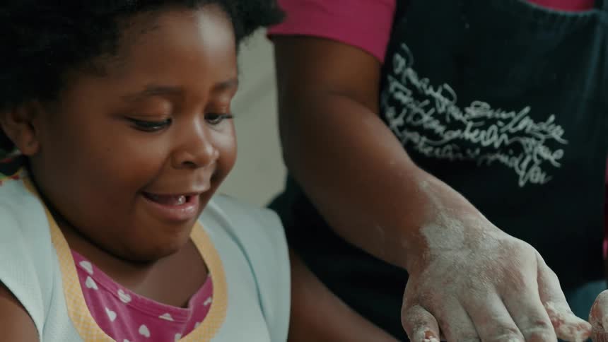 The girl is grinning as she cooks at home