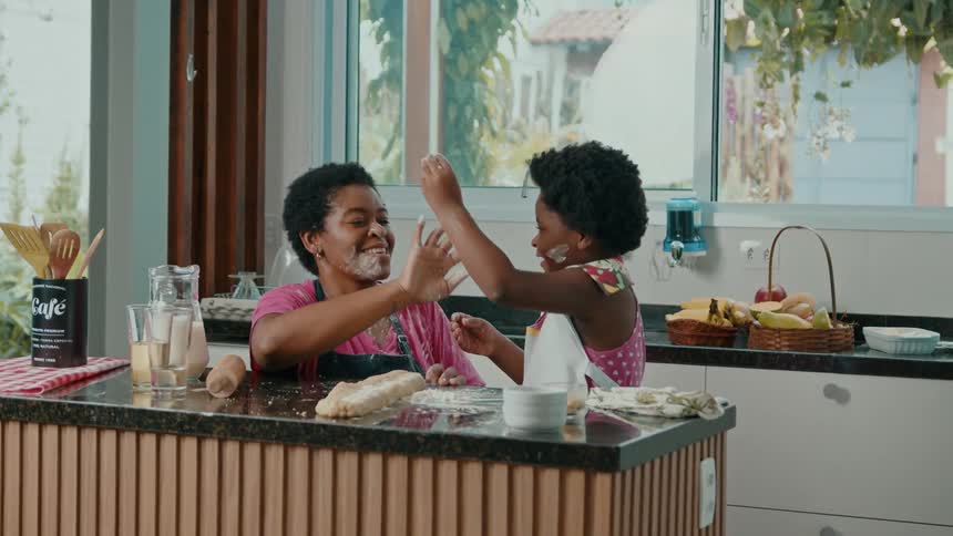 A mother and daughter wipe flour on their faces
