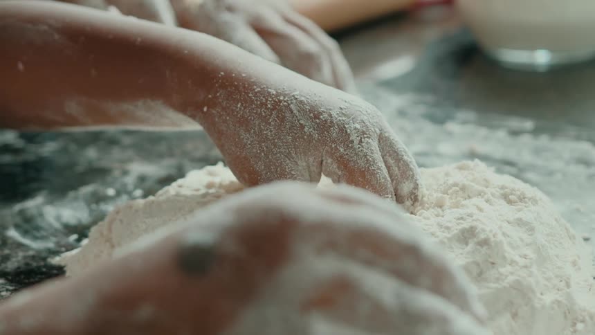Pair of hands interacting with wheat flour