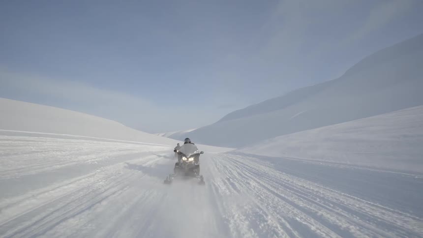 Two snowmobiles race together