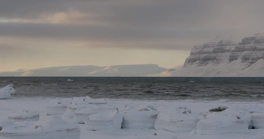 Large rocks line this snowy shore
