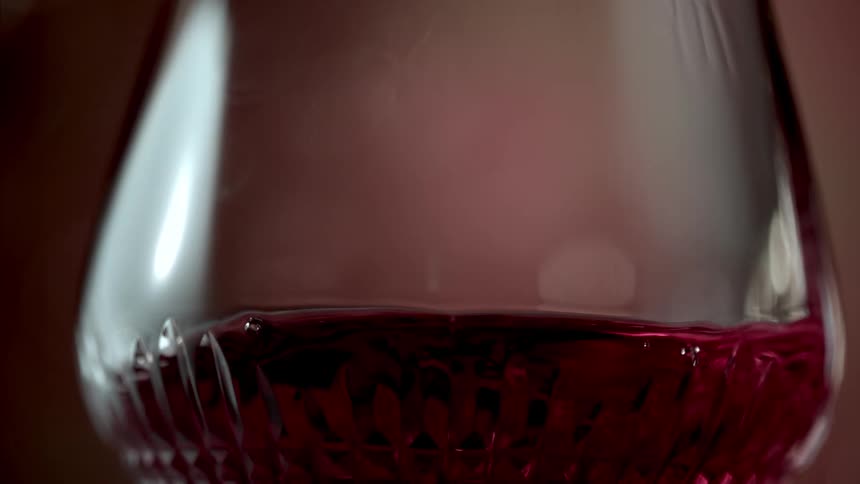 The red wine is moving back and forth in the glass
