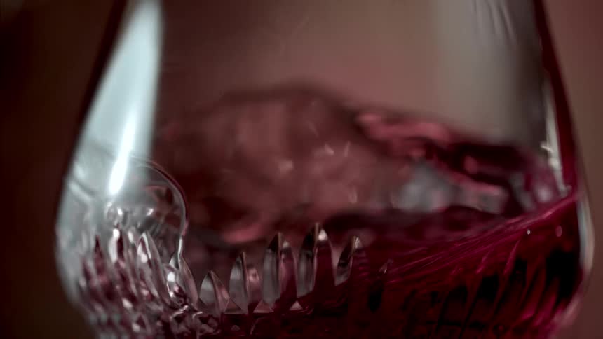 Red liquid inside a glass bottle shaking