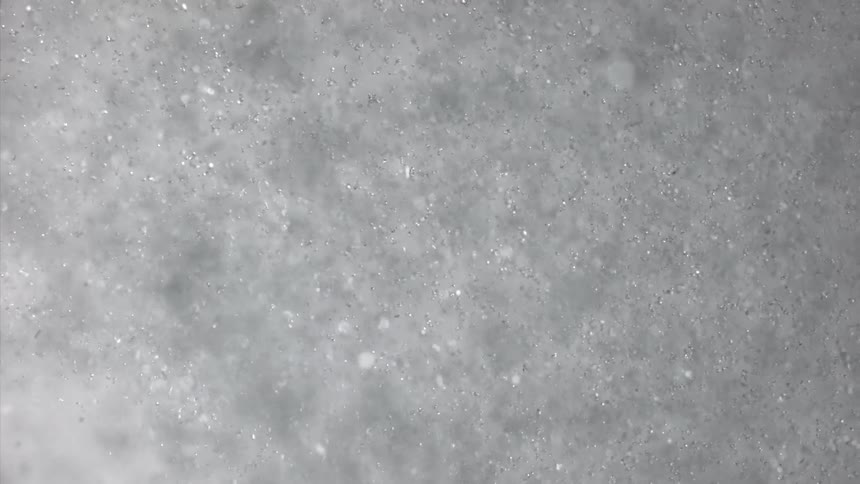 Bubbles glisten as they get blown across the surface of the water