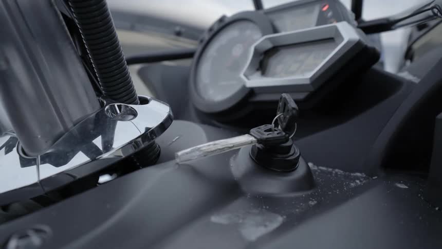 A person turns the key in an ignition