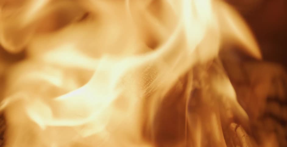 Orange flames char pieces of wood