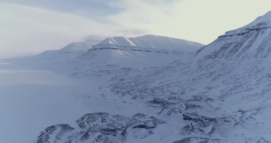 A view of a snow covered mountain scene with the sky in the background