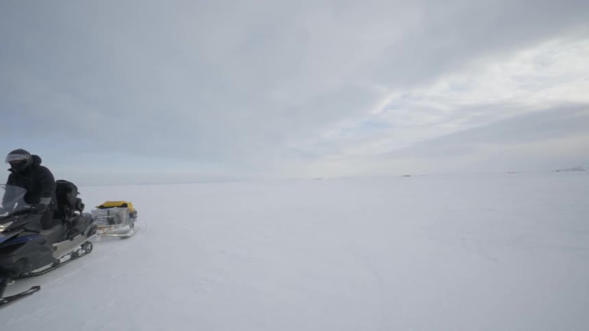Person drives a snow ski through a flat field of snow