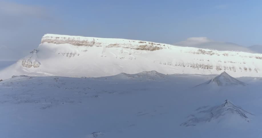 The field and mountain are covered with snow