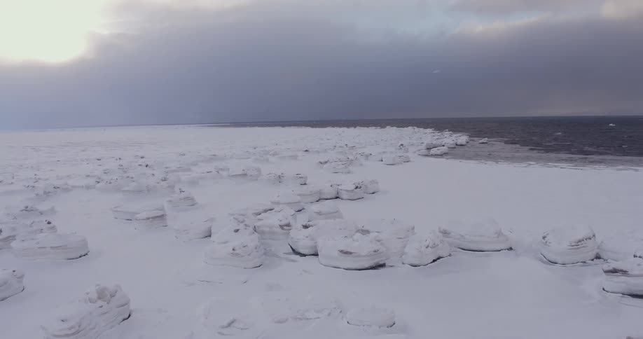 Snow covers a coastal landscape