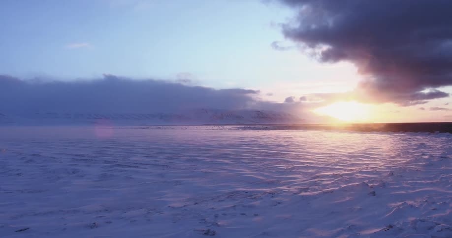 The sun rises over a snowy plain