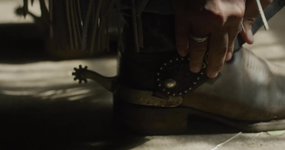 Man fastens buckle on his cowboy boot