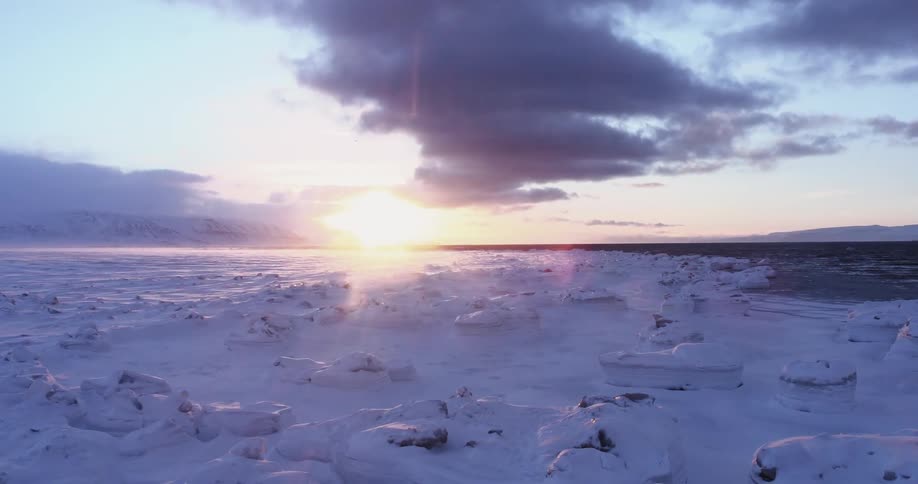 The sun is setting over this icy shore