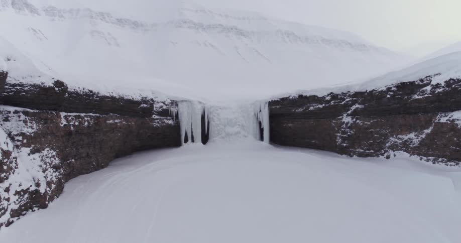 The lip of this cliff is covered with ice and snow