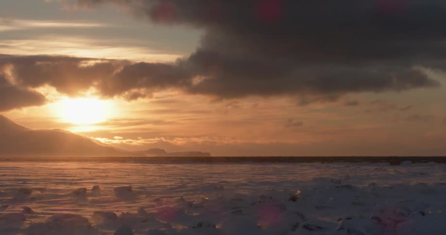 The sun sets over an icy landscape