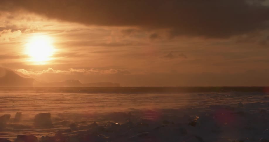 The waves crash against the shore at dawn
