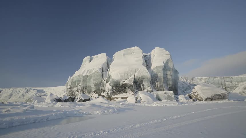 The snow covered field is lined with mountains