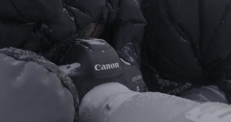 A person is operating a camera in the snow