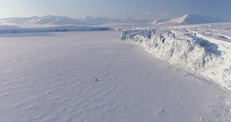 A snowmobiler rides in the snowy wilderness