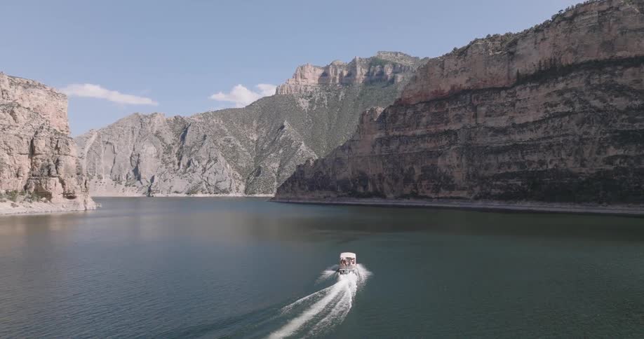 Boat cruising on a lake nestled between canyons
