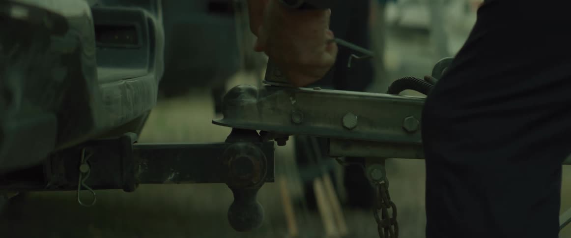 Pair of hands of a person attaching a hitch to a vehicle