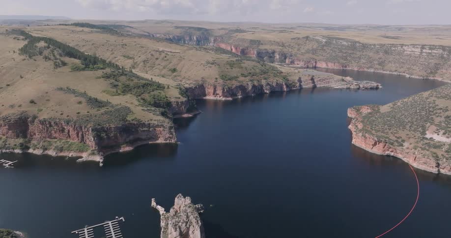 A pier is in the river by the cliffs