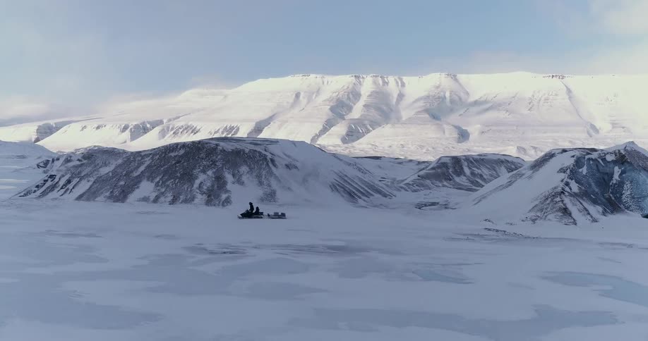 A person rides a snowmobile in the snow