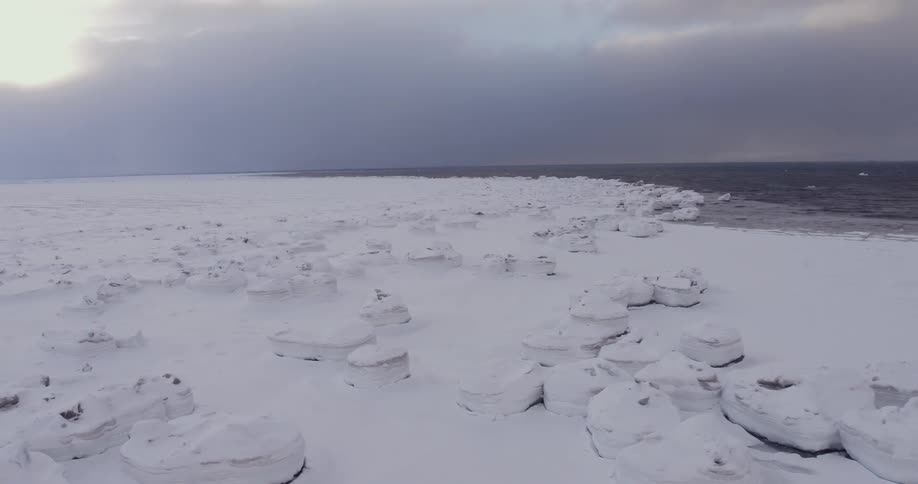 Snowy plains next to the water on a cloudy day