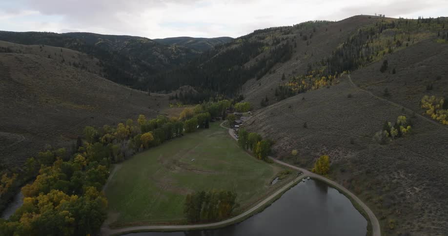 Aerial panorama of a lake surrounded by trails and mountains