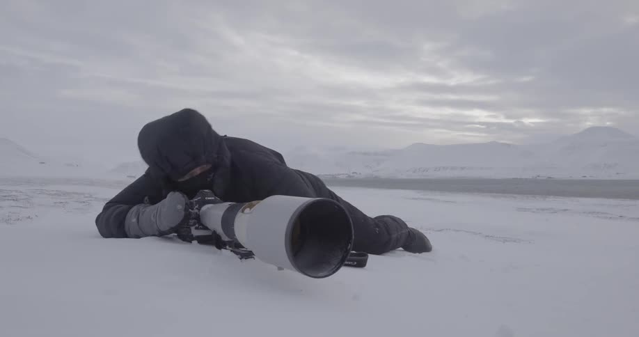 A person taking pictures in the snow