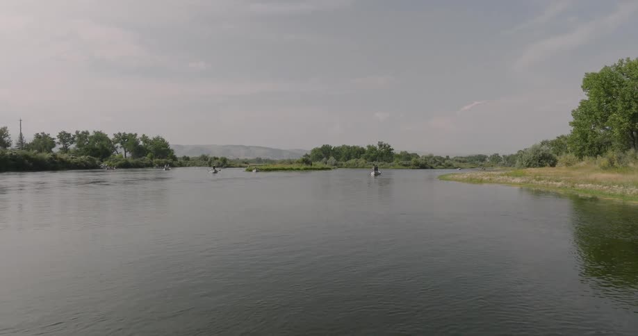 Buoys evenly spaced in a lake with trees on the shore
