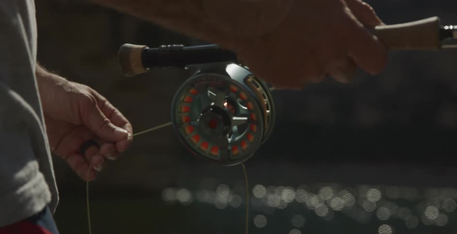 A man is pulling on the string of the fishing pole