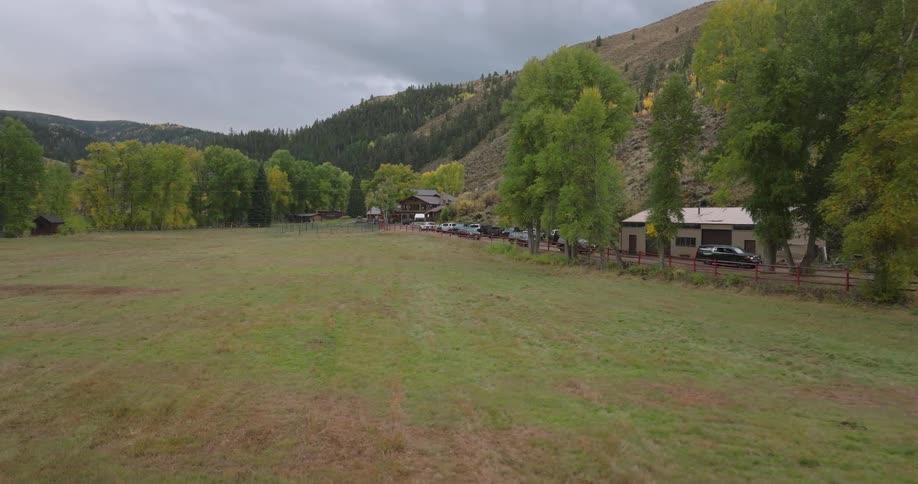 Cars drive down a road next to a field