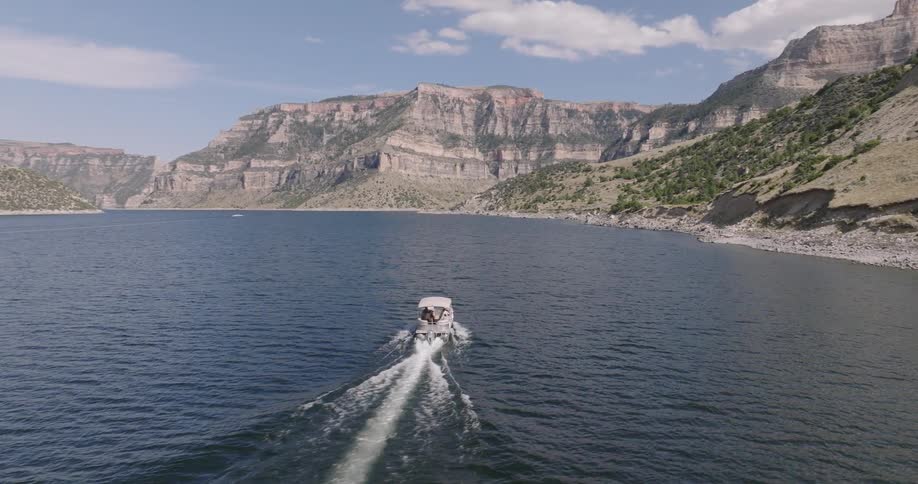 A boat moves across the water in a mountain lake