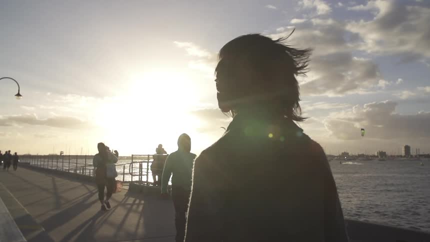People walk on a boardwalk in slow motion